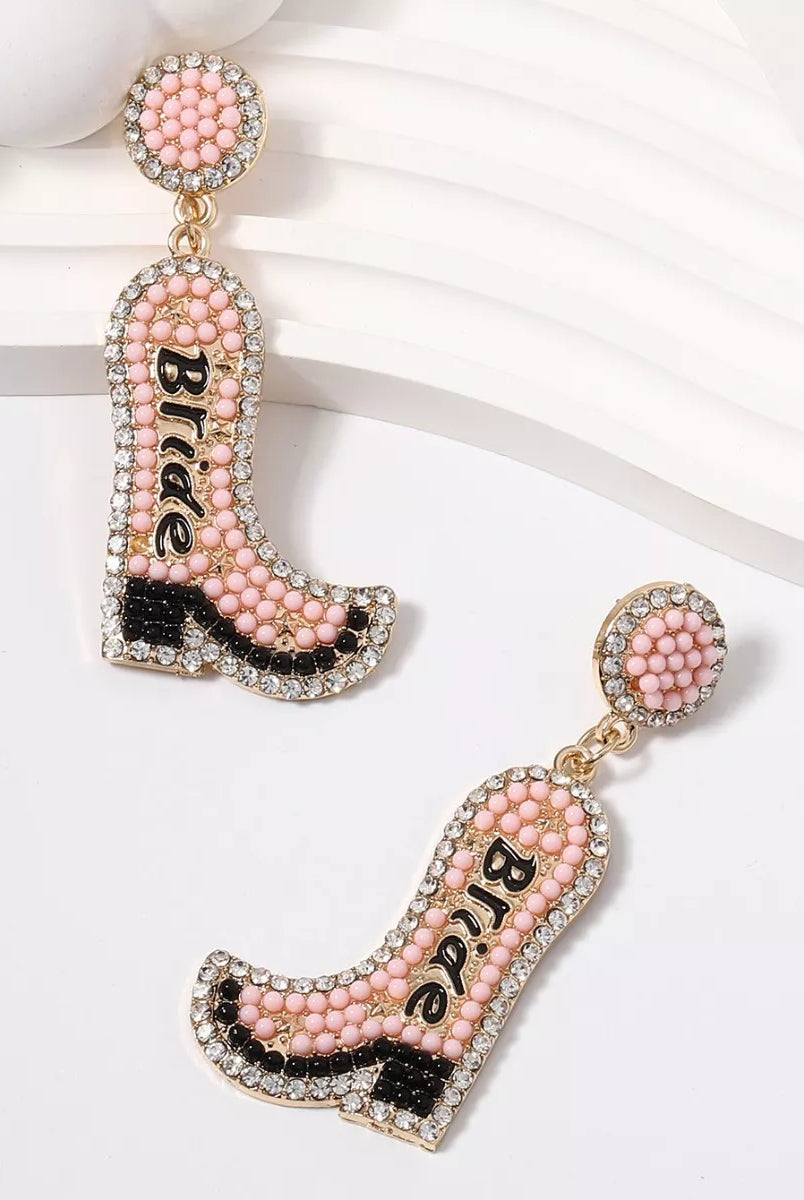 Pink cowboy boot earrings with 'Bride' text on a white background