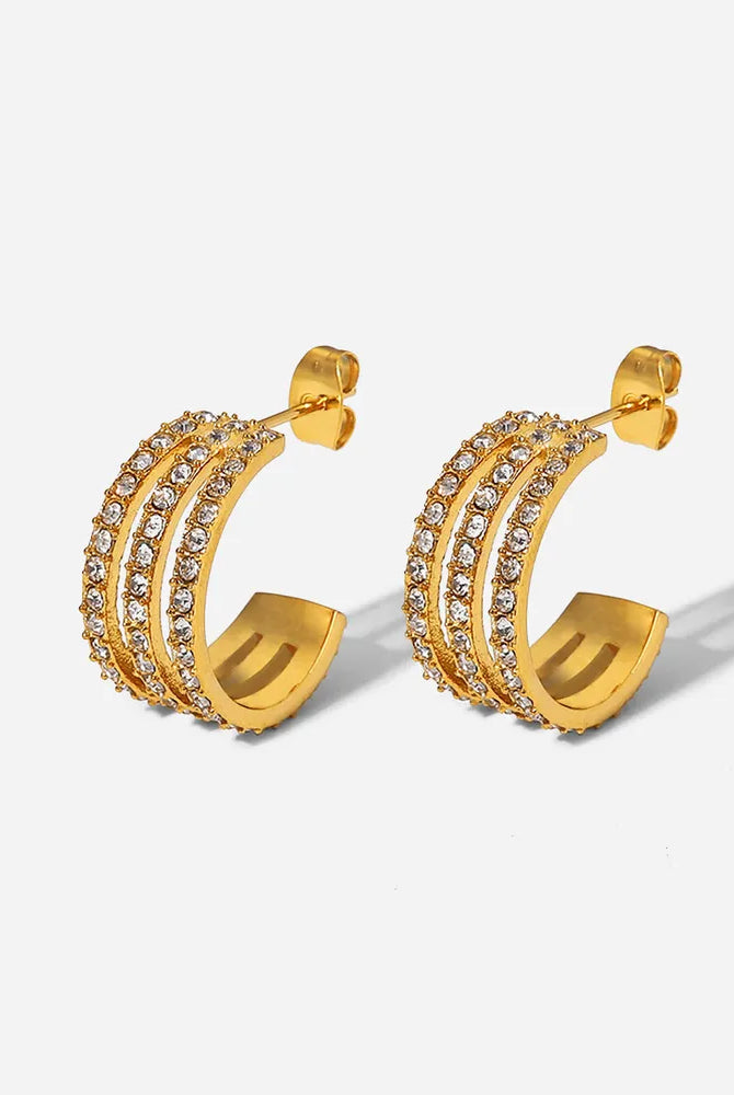 Gold hoop earrings with embedded stones on a light gray background