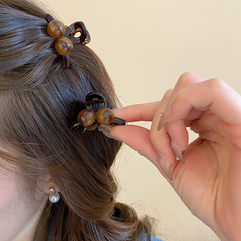 Side view of the luxury tortoise shell acrylic hair claw clip highlighting the strong gold-toned metal spring mechanism and secure grip teeth.