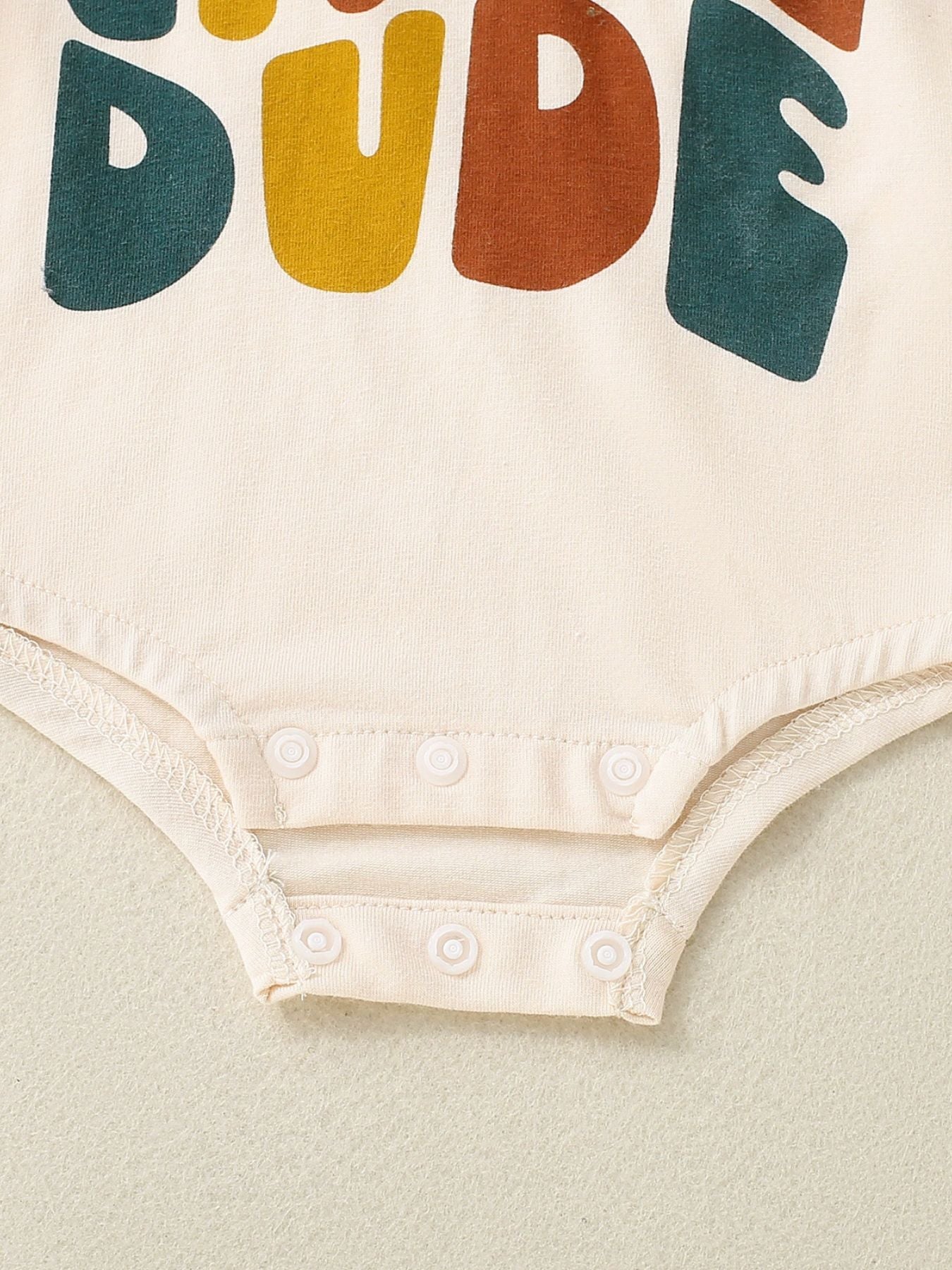 Baby onesie with colorful text on a light background