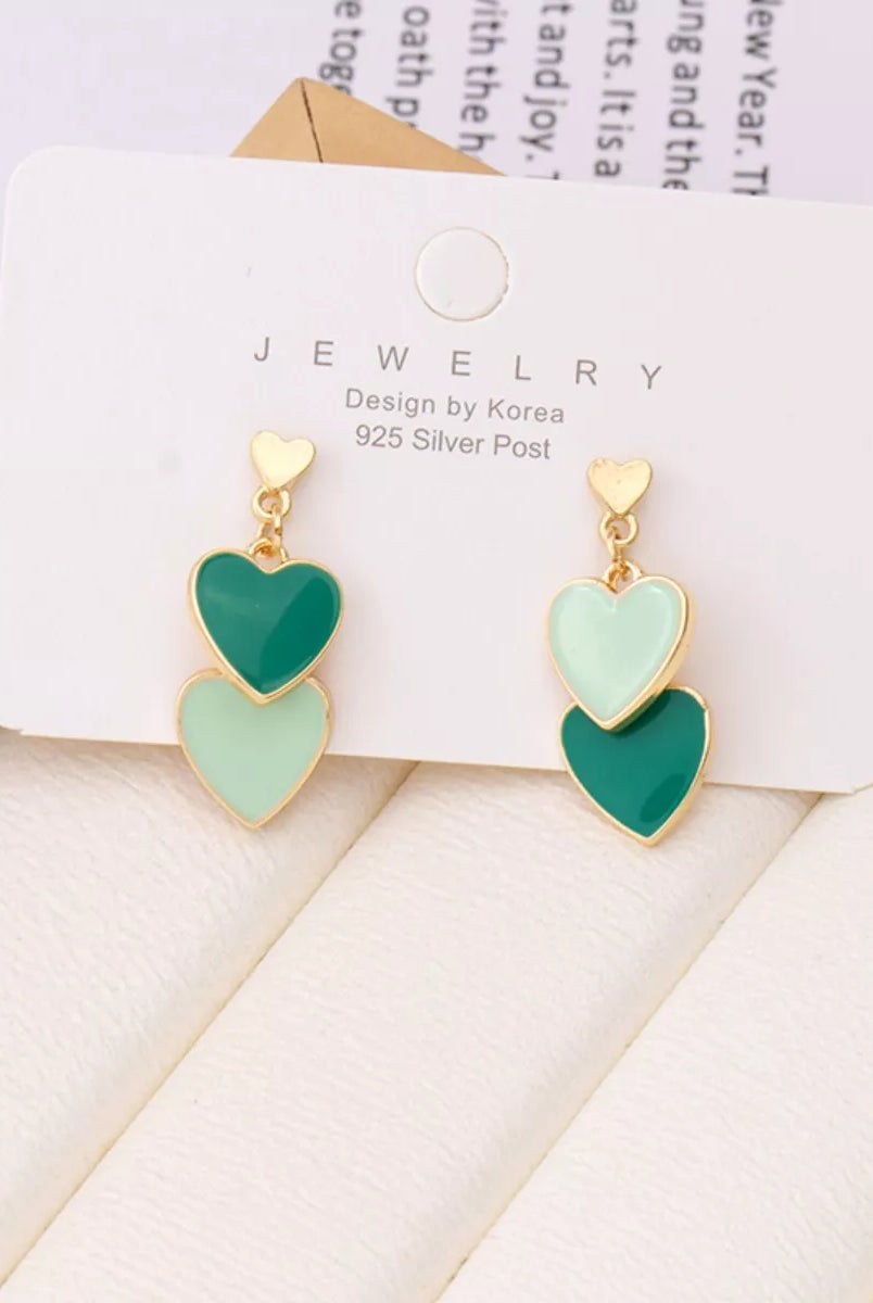 Green heart-shaped earrings on a jewelry card with a light background