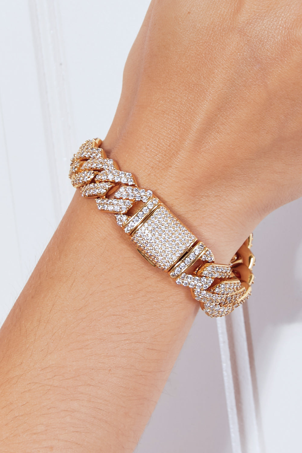 Rose gold bracelet with diamond accents on a wrist against a light background