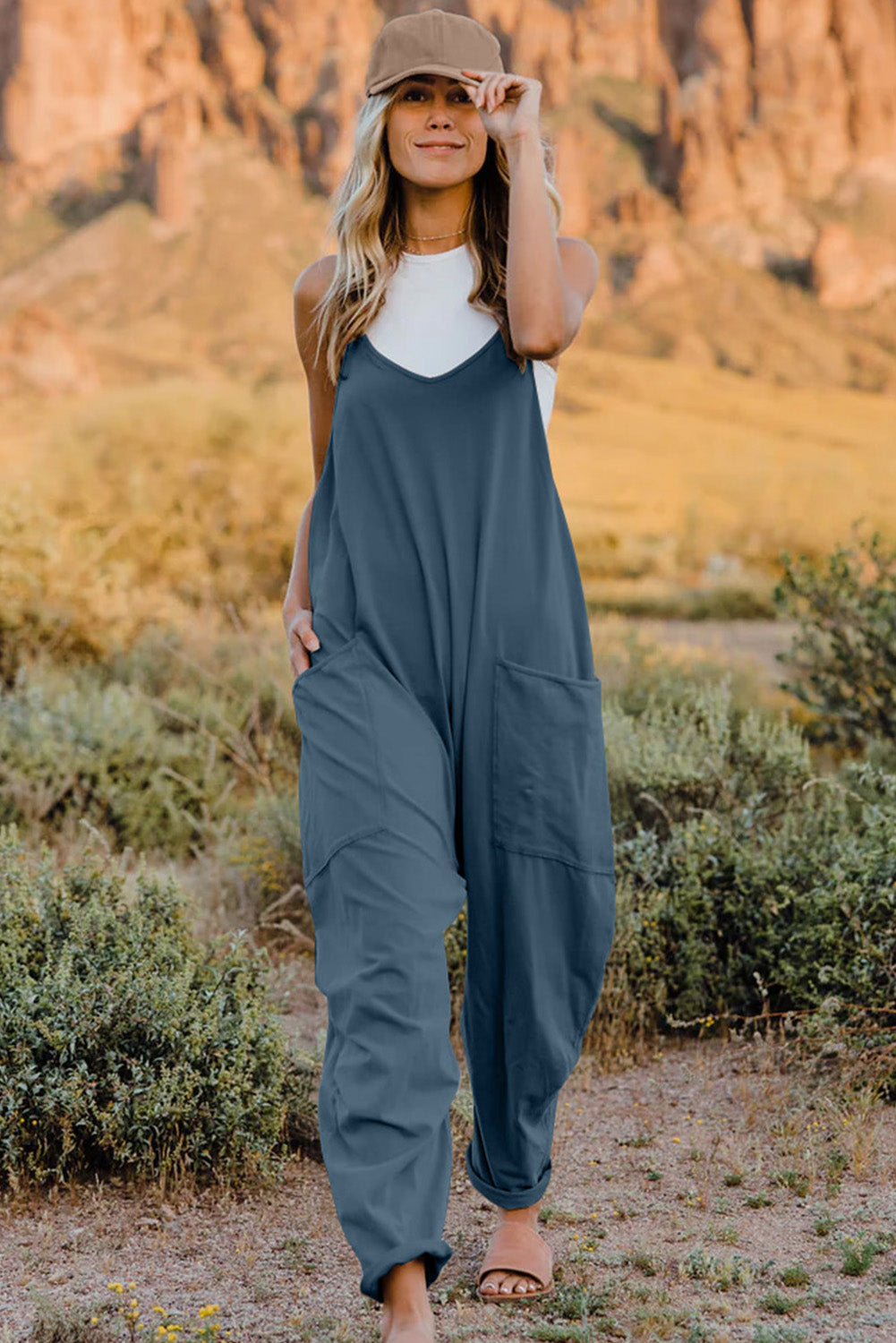 Our Double Take Jumpsuit combines chic design with practicality, ideal for any event. It boasts a flattering V-neckline, a sleeveless cut for comfort, and handy pockets for added functionality. This essential garment ensures you stay poised and stylish with ease.