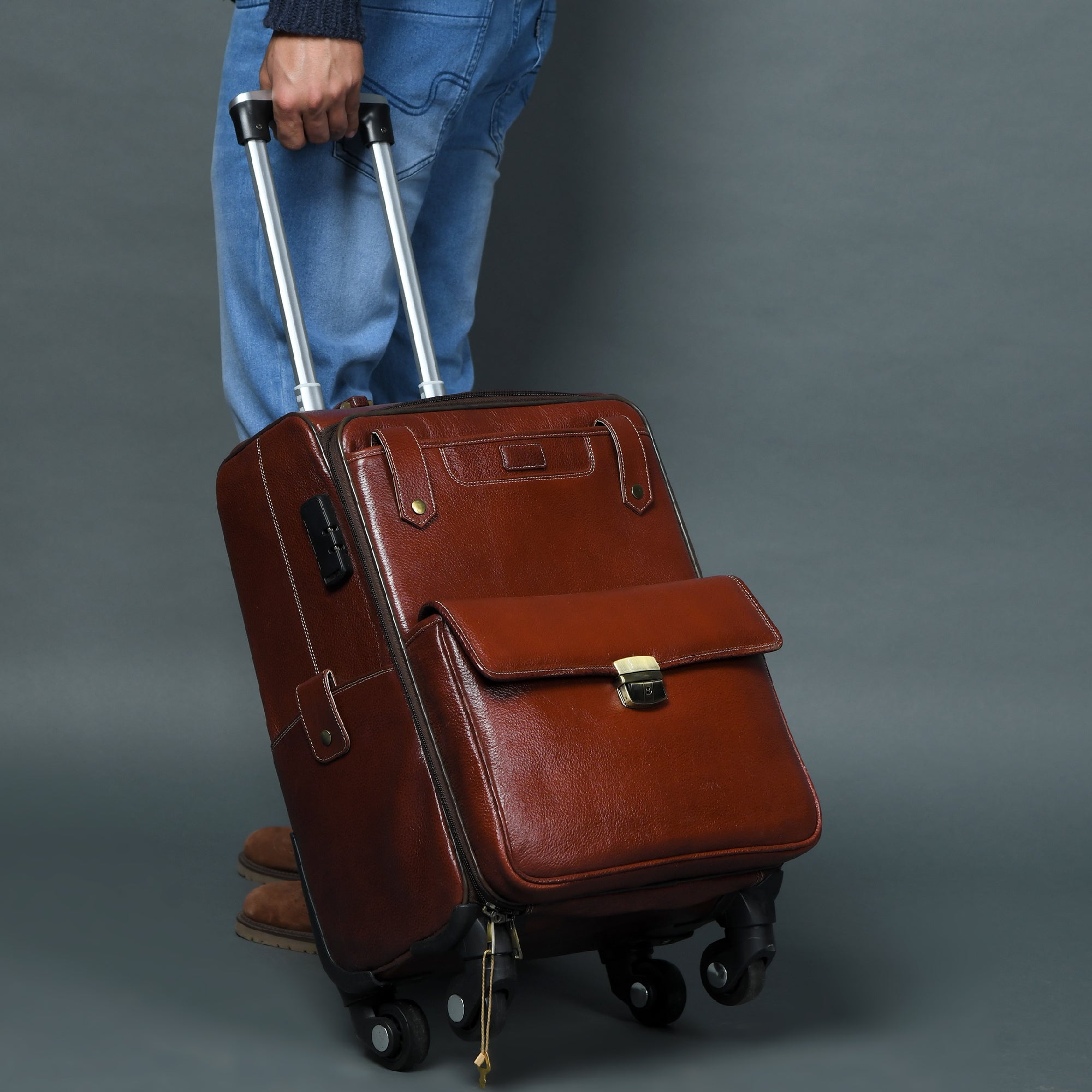Brown leather suitcase with wheels on a gray background