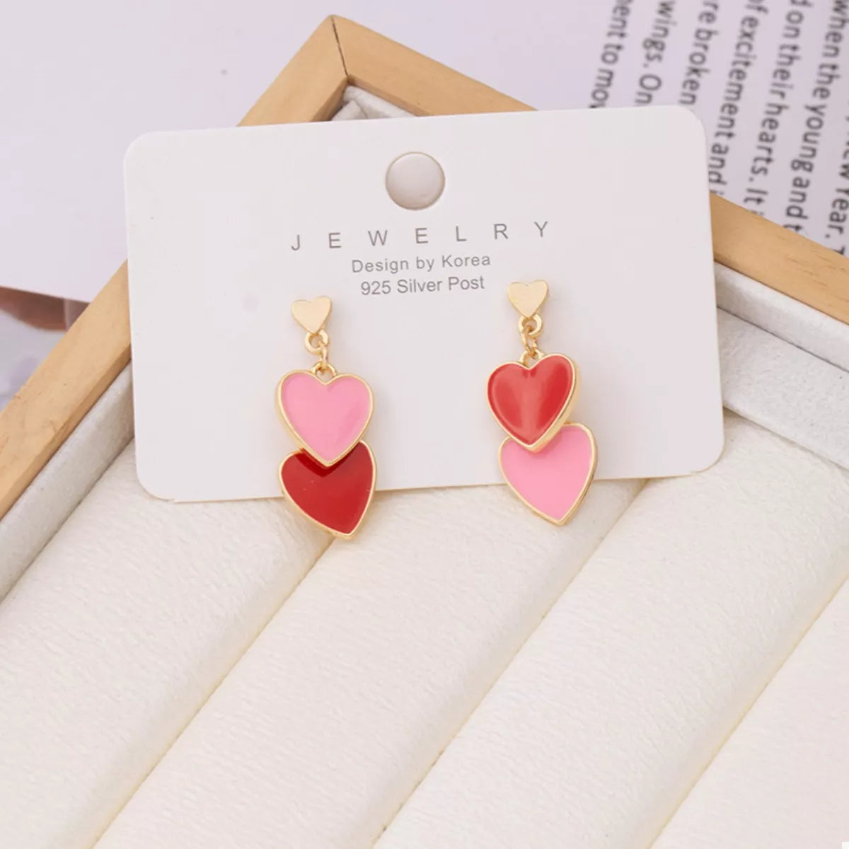Heart-shaped earrings on a jewelry card with a white background