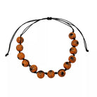 A beaded necklace made of round orange beads with black spider illustrations, strung on a black adjustable cord against a plain white background.