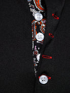 Close-up of a black coat with decorative buttons and patterns.
