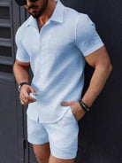 Man wearing a light blue textured shirt and shorts set against a dark background