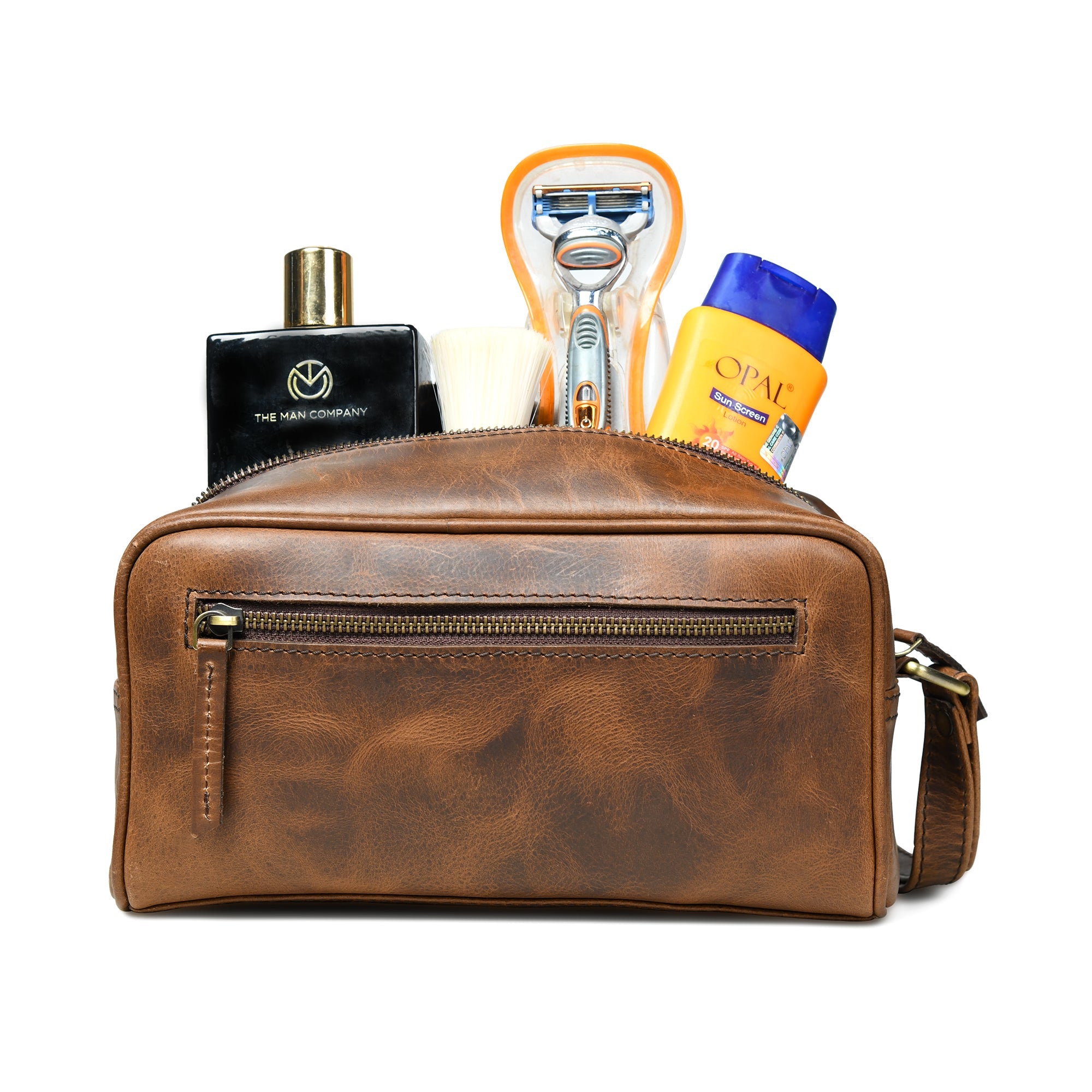 Brown leather toiletry bag made of buffalo leather with grooming products on a white background