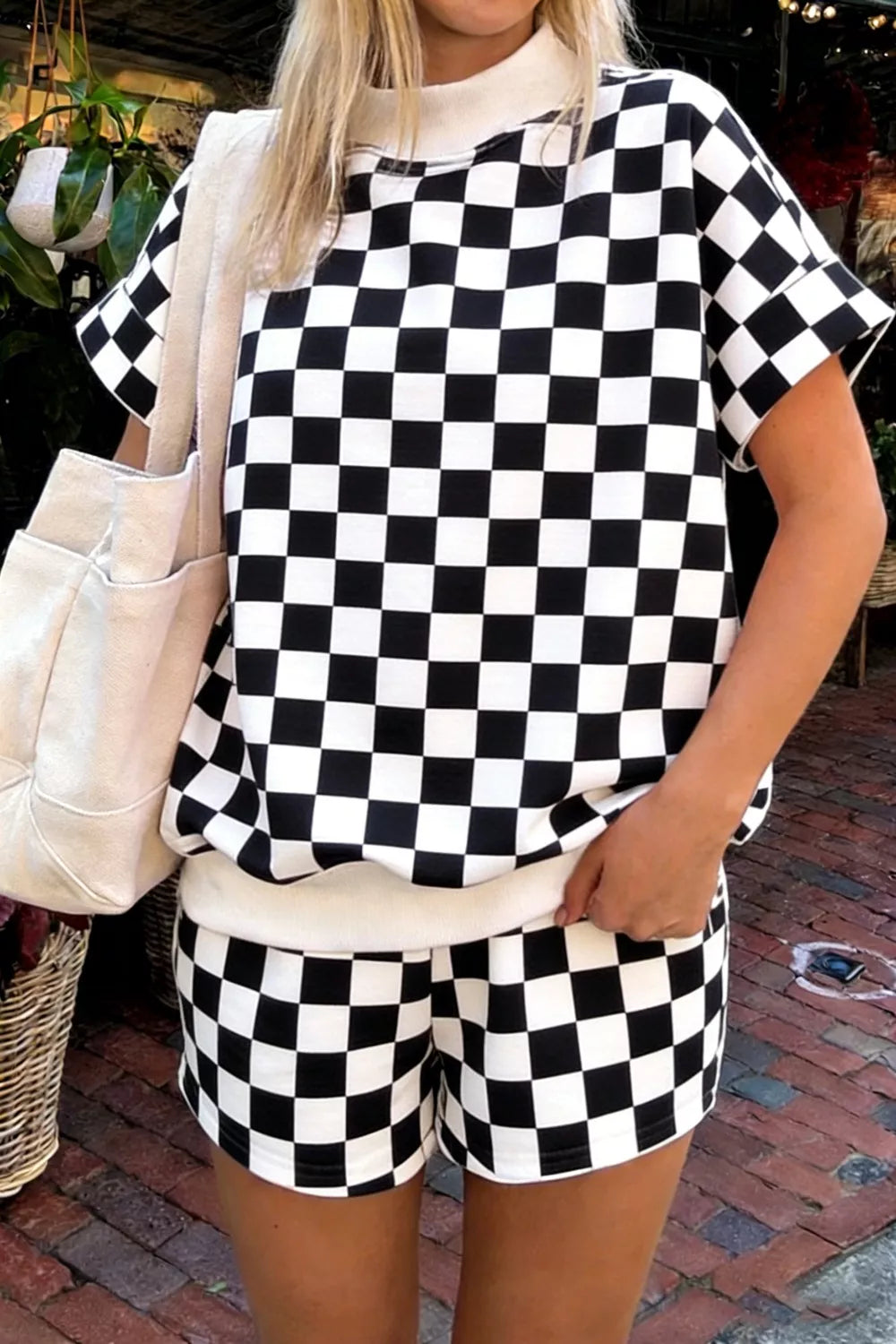 Front view of women's two-piece checkered luxury lounge set with a subtle geometric textured knit short-sleeve shirt and matching drawstring shorts in classic black.