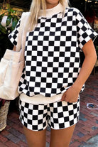 Front view of women's two-piece checkered luxury lounge set with a subtle geometric textured knit short-sleeve shirt and matching drawstring shorts in classic black.