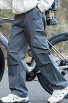 Person wearing gray cargo pants with a bicycle in the background
