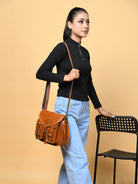 Woman carrying a brown leather bag against a beige background