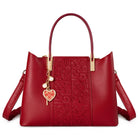 Red handbag with a heart-shaped charm on a white background