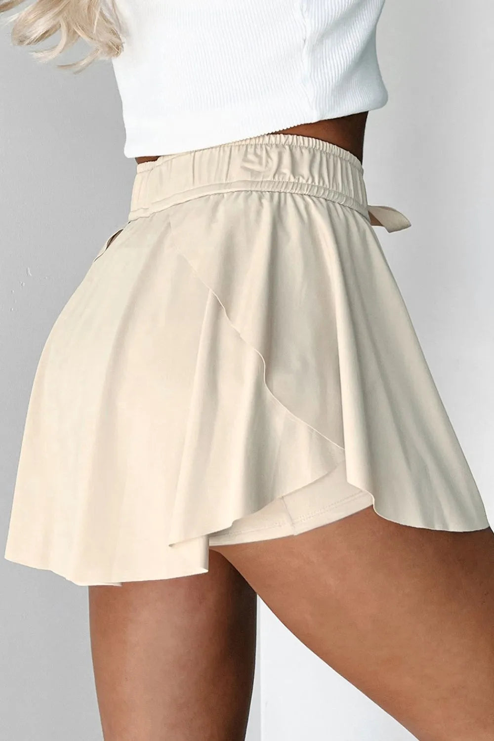 Beige shorts worn by a person on a plain background