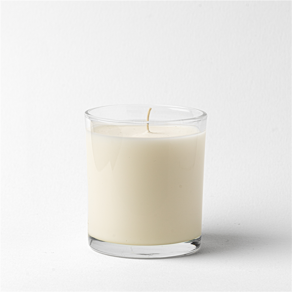 White candle in a clear glass container on a white background