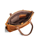 Brown leather handbag with open interior on a white background