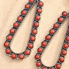 Necklace with red beads and black and white accents on a wooden surface