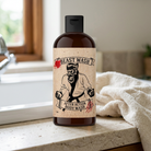 After Action Body Wash amber bottle beside a white bathroom sink and ivory towel.