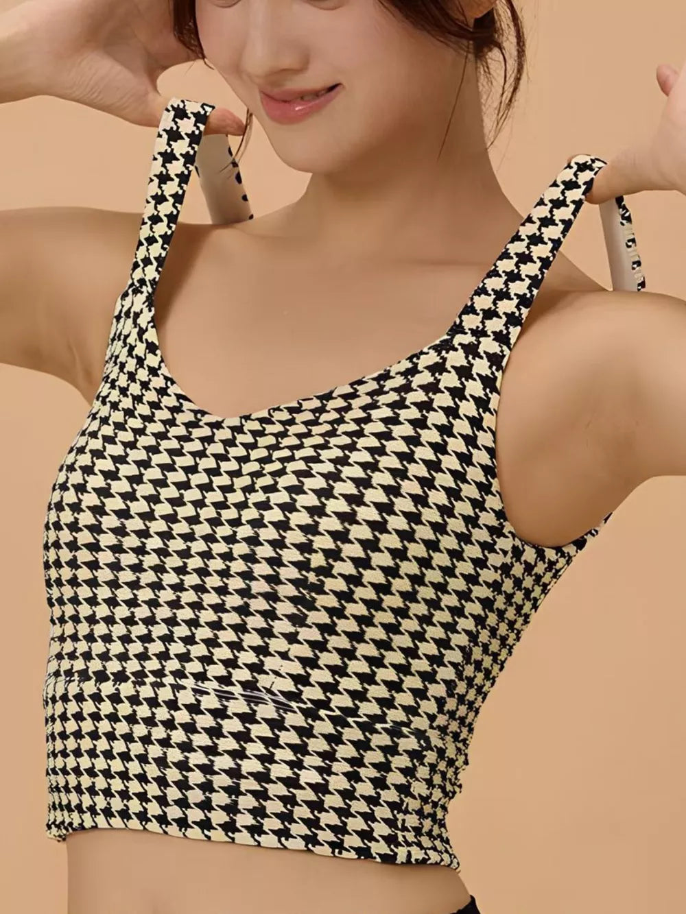 The Crisscross Back Houndstooth Active Top offers a sophisticated blend of style and performance. Perfect as a bra worn under a button-up shirt, it elevates your look with its classic houndstooth pattern and modern crisscross back design. This versatile top suits fashion-forward outfits, spa-inspired relaxation, or casual wear, providing both support and refined comfort throughout your day.