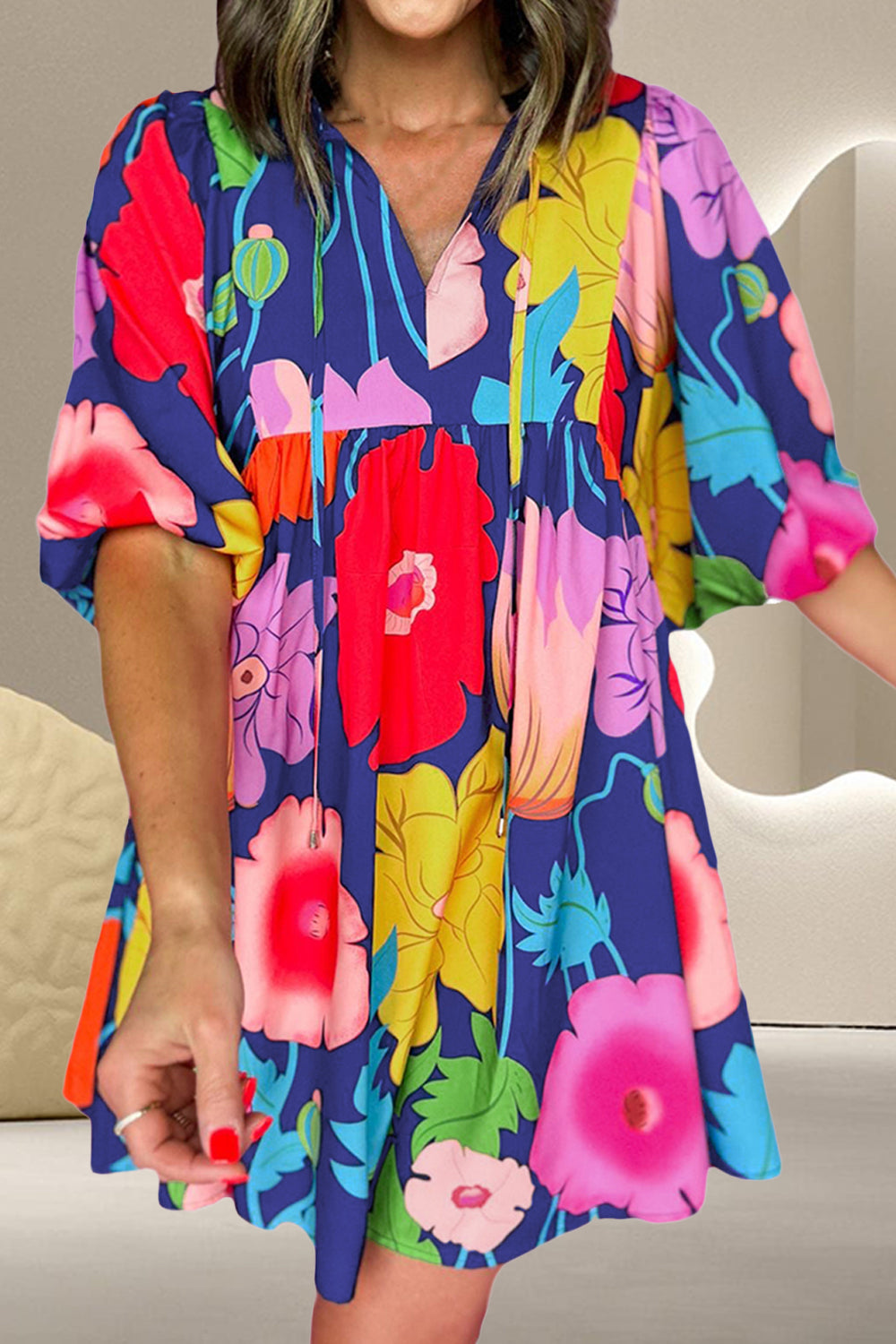 Front view of floral cotton mini dress with tie neckline, half sleeves, and colorful blooms on a navy background.
