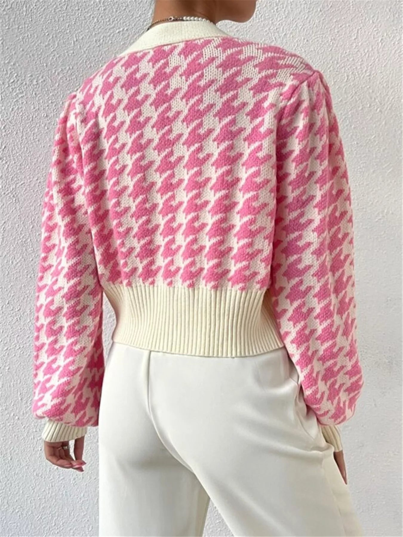 The Houndstooth V-Neck Button Up Cardigan features a classic pattern and tailored fit. Its V-neck design layers easily over shirts, and the button-up front adds adjustable comfort. This versatile cardigan suits both professional and casual looks while offering lasting quality.