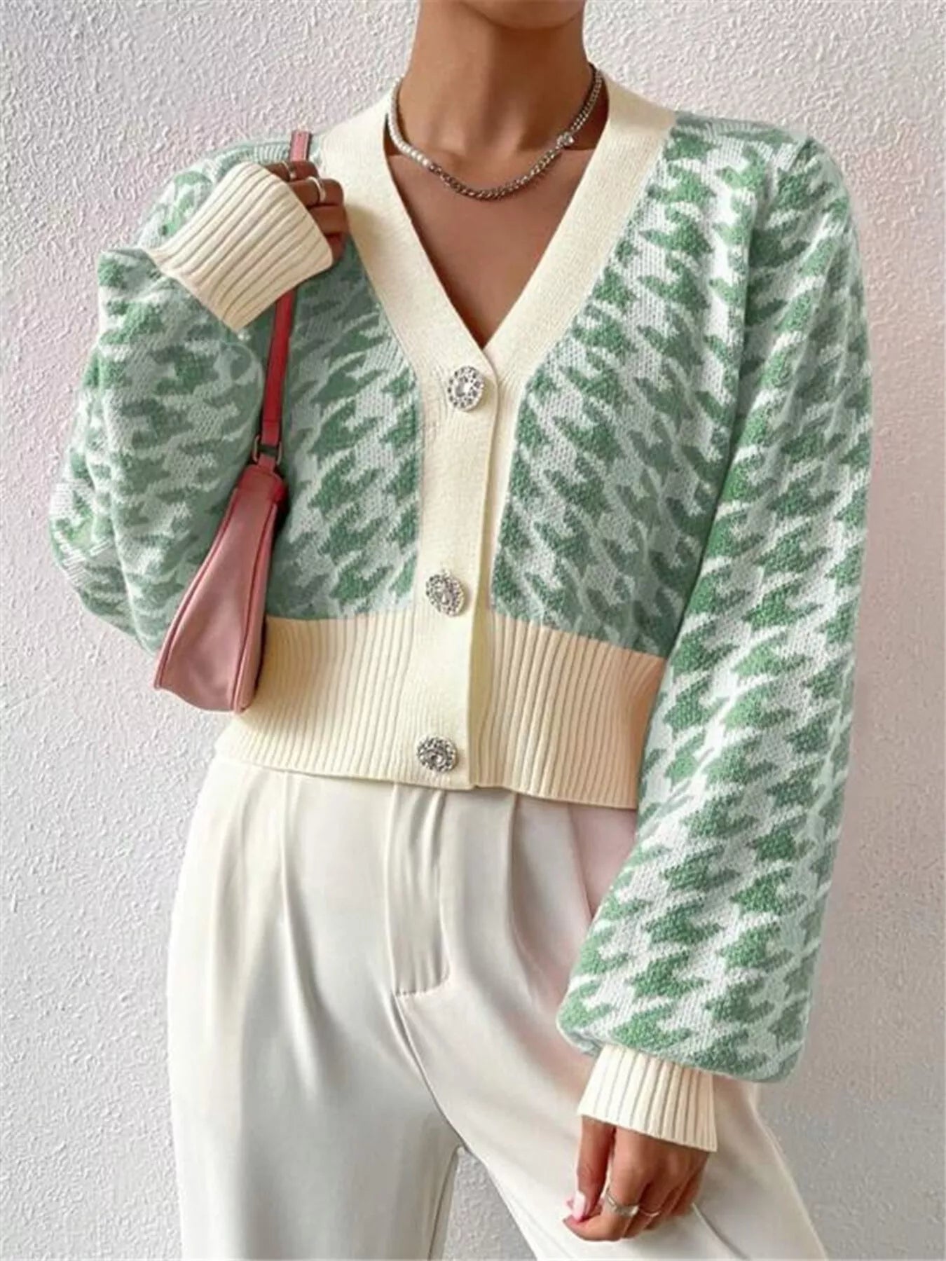 The Houndstooth V-Neck Button Up Cardigan offers a classic pattern with a tailored fit. Its V-neck design layers well over shirts, and the button-up front ensures adjustable comfort. This durable cardigan is perfect for both work and casual wear.