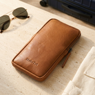 Brown leather phone sling in a travel-packing scene