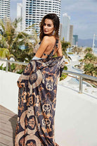 Woman in a patterned dress standing on a rooftop with a cityscape in the background