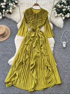 Yellow pleated dress on a hanger with decorative background