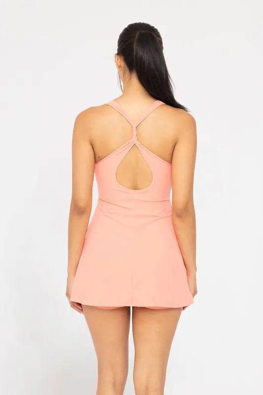 Woman wearing a pink dress with a cut-out back on a white background