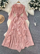 Pink ruffled dress on a hanger with decorative elements on a textured surface.