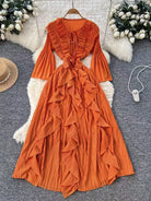 Orange ruffled dress on a hanger with decorative elements in the background