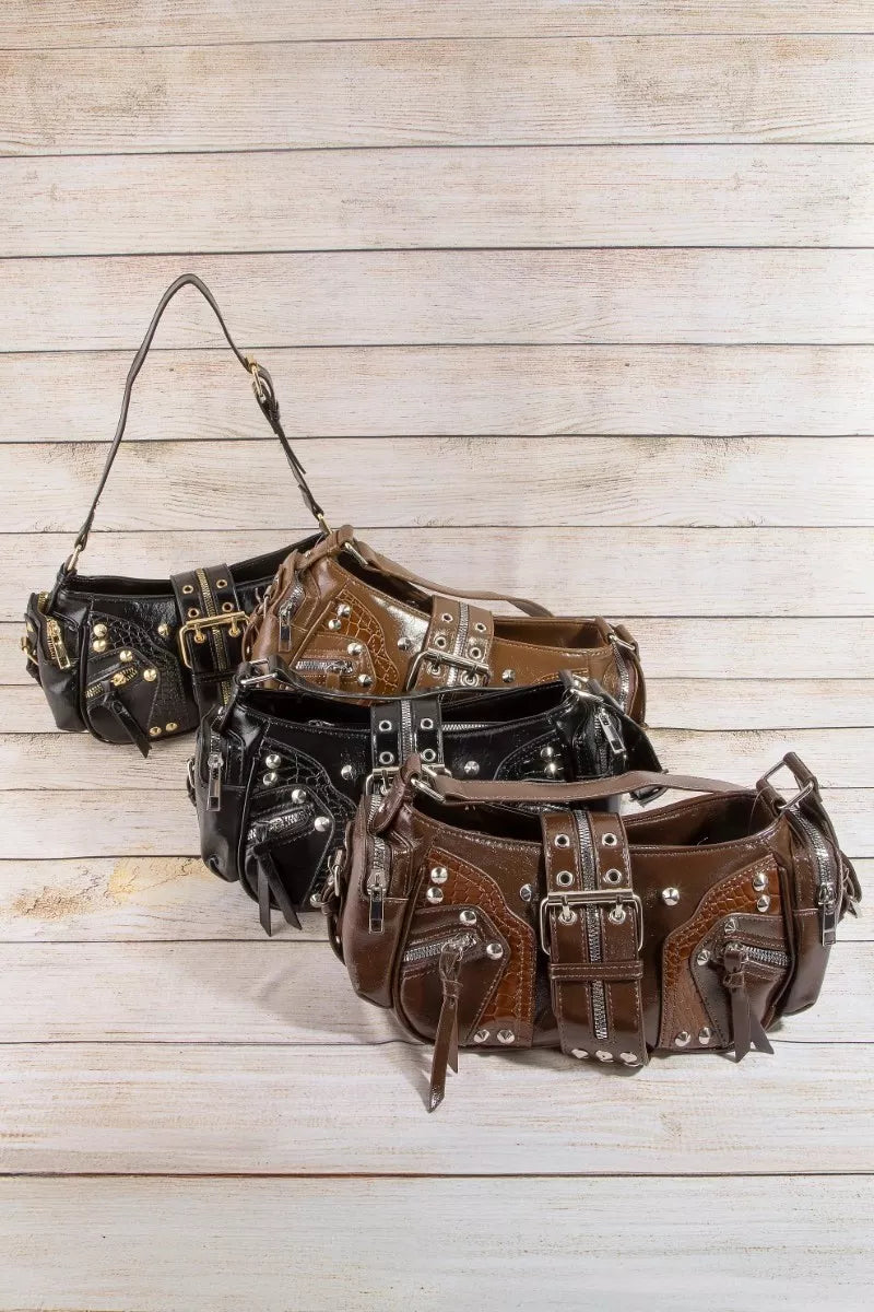 A detailed close-up view of the Stella bag, showcasing the beautiful texture of the genuine leather and the precise, high-shine finish of the hardware studs. Brown and Black handbags.