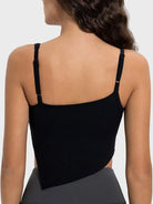 Black strappy top worn by a person on a light gray background