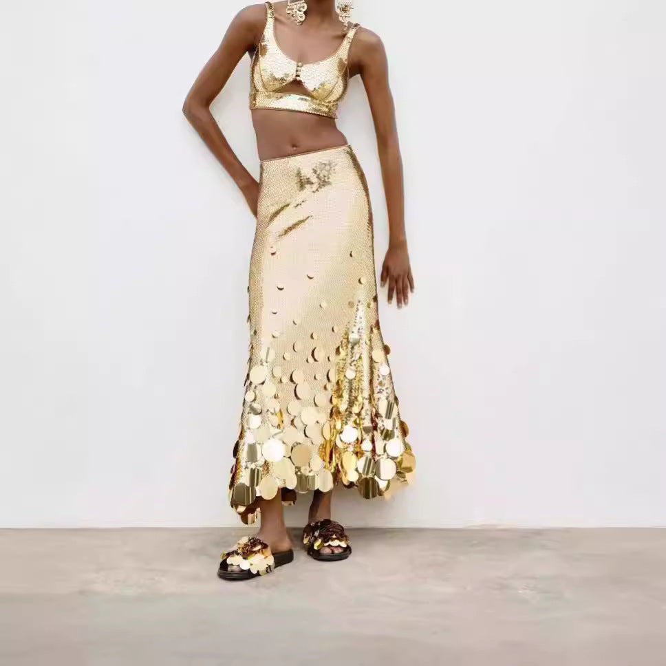 Person wearing a gold sequin outfit against a white background