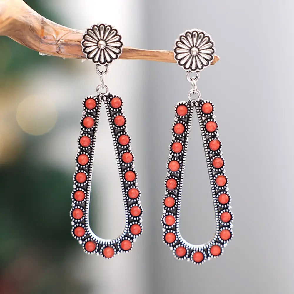 Silver alloy teardrop earrings with red beads and a carved sunflower top post.