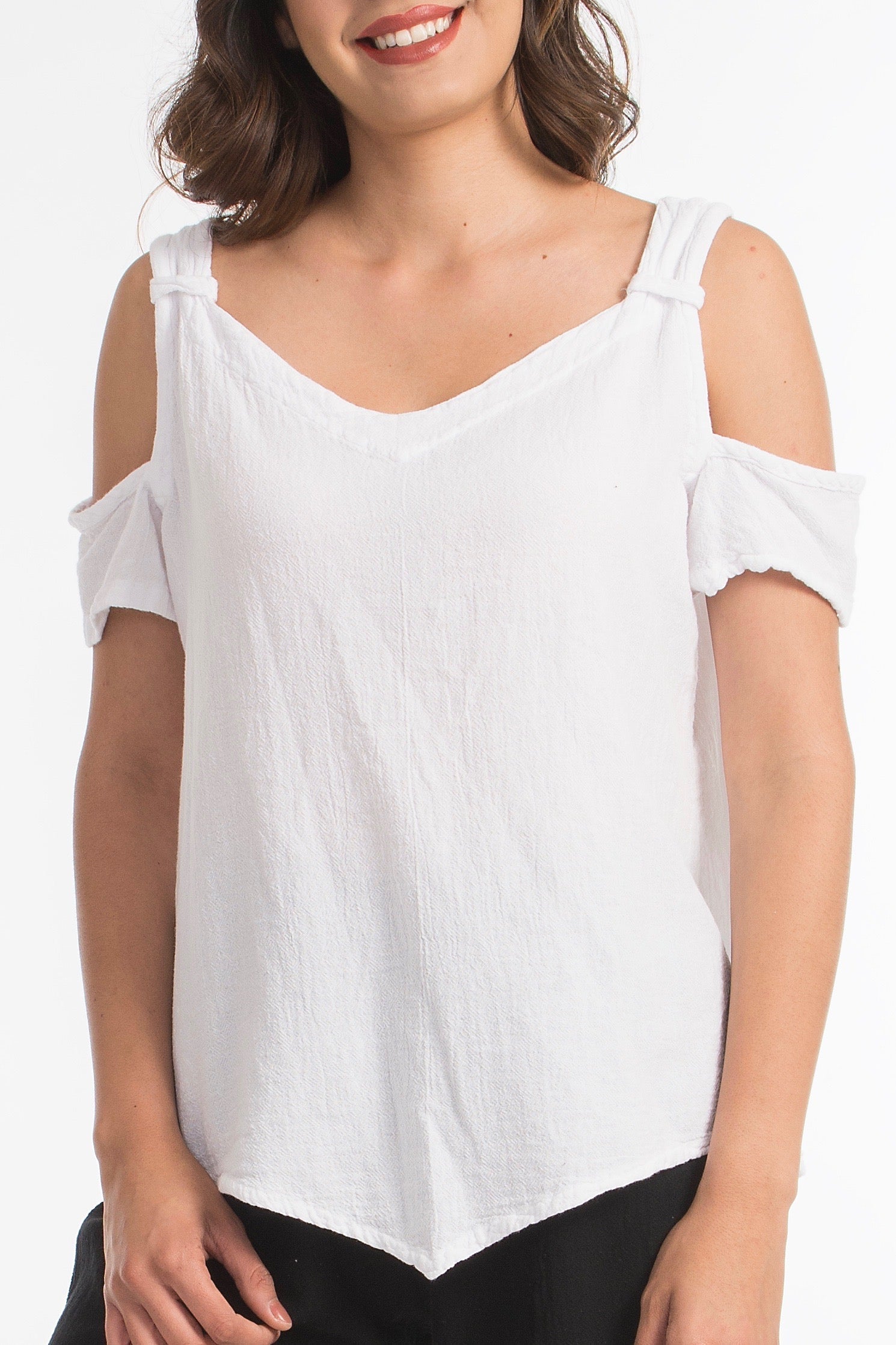 Woman wearing a white cold-shoulder top on a white background