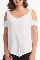 Woman wearing a white cold-shoulder top on a white background