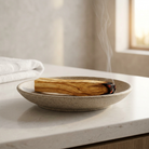 Palo santo stick smoldering in a heat-safe dish