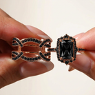 Ring components held between fingertips against a clean ivory background