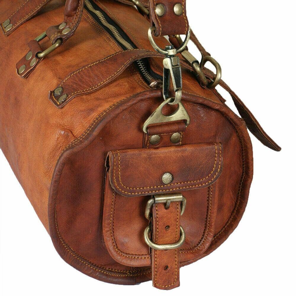 Brown leather duffel bag with brass hardware on a white background